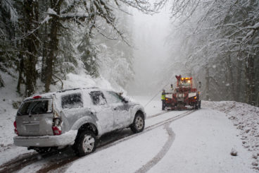 silver estate car being towed in the snow