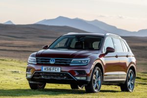 Red Volkswagen Tiguan parked in a field