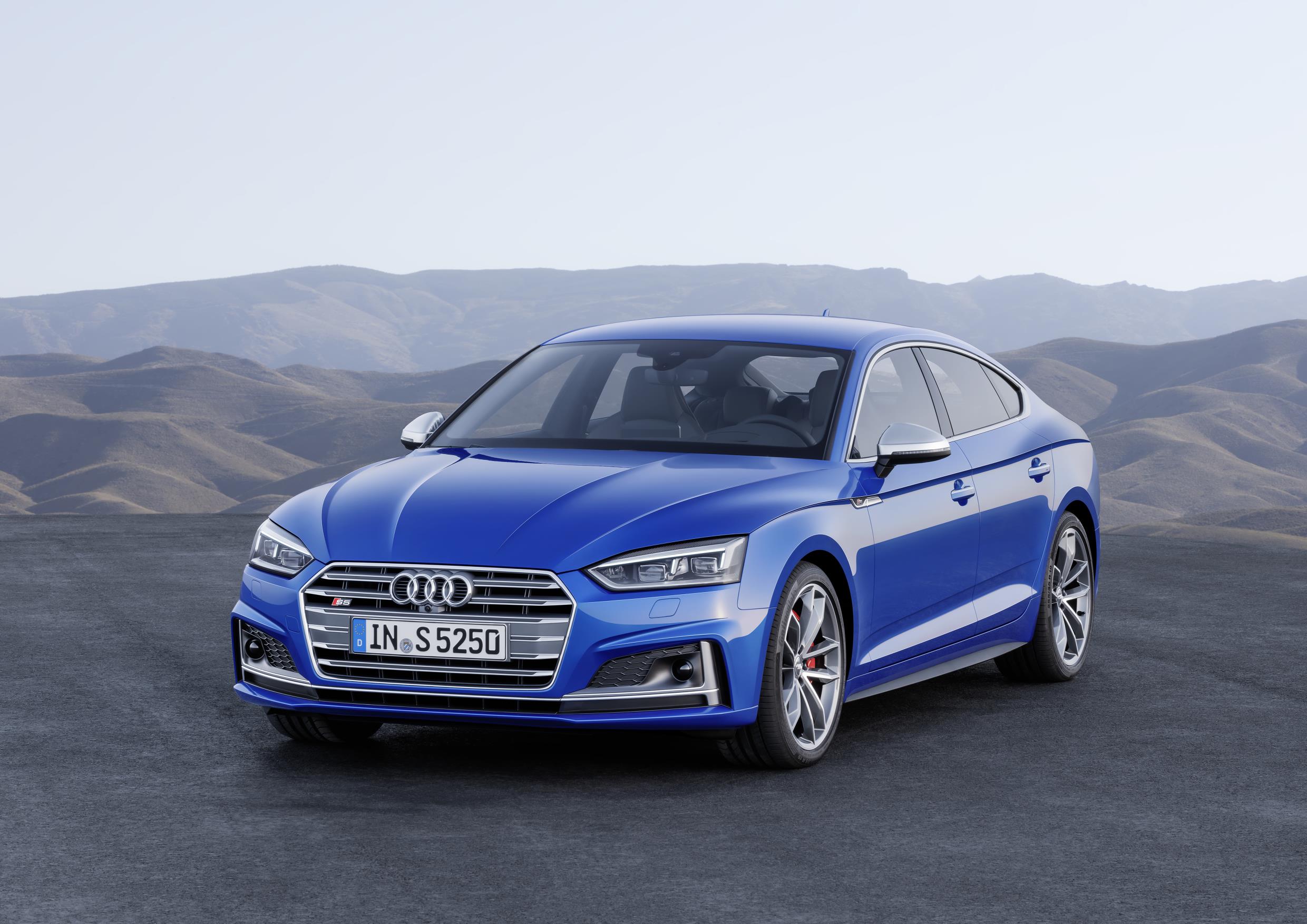 Blue Audi S5 Sportback parked infront of mountains