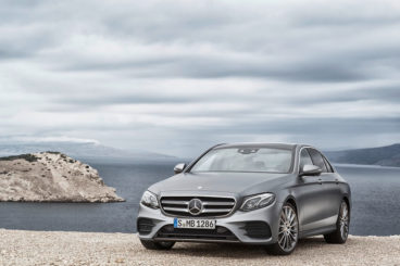 Mercedes E Class Saloon in silver on cliff edge with sea behind
