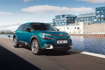 blue coloured citroen c4 catcus hatchback parked in harbour right next to water