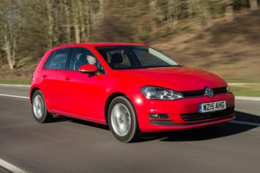 Volkswagen Golf in red driving on the road