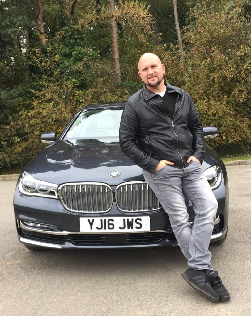 Tim Barnes Leaning on a BMW 740Ld xDrive