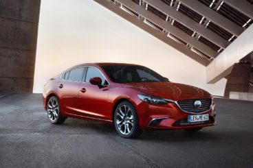 metallic red mazda 6 sportswagon parked under modern building