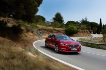 Mazda 6 Saloon in red driving around corner