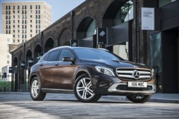 Mercedes GLA Class parked in front of bridge in a city
