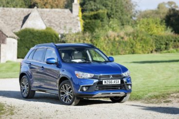 dark blue Mitsubishi ASX parked on gravel with country house in the background