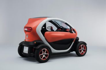 a metallic orange renault twizy coupe isolated on a white/grey background