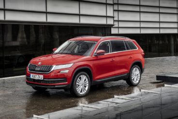 a bright red skoda kodiaq parking in the rain