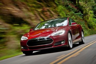 Tesla Model S front view fast driving red paint