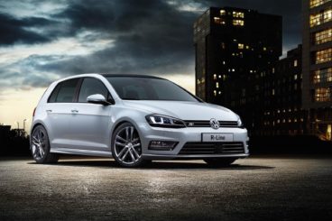 metallic white vw golf r line parked next to dark city