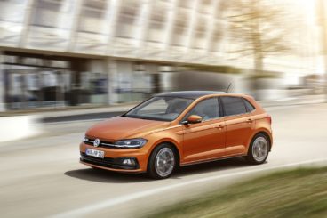 metallic Volkswagen polo hatchback turning corner with blurred background