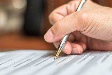 Someone signing paperwork