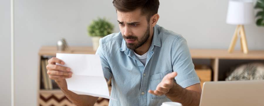 Man looking at invoice, confused at costs
