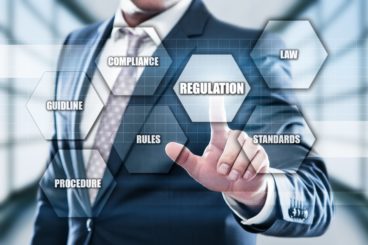 Man pointing towards the regulations button on a concept image