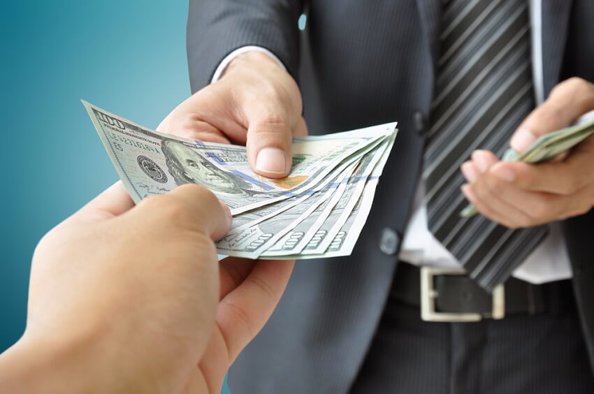 Man handing out cash - buying a car with cash