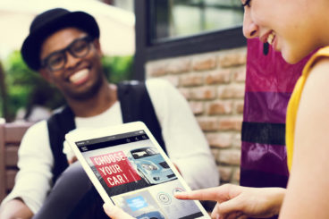 Woman on her ipad laughing with her male friend