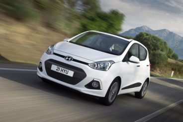 White Hyundai i10 driving on road fast