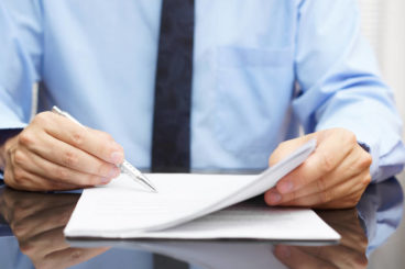 man going through documents with a pen