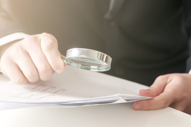 man reading a document with a magnifying glass
