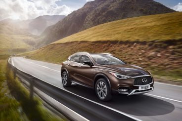 the Infiniti QX30 driving with mountainous background