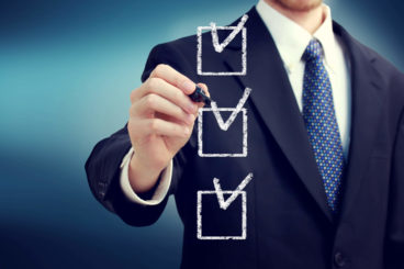 man wearing a suit ticking off checklist