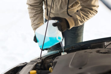 person pouring anti-freeze into their car