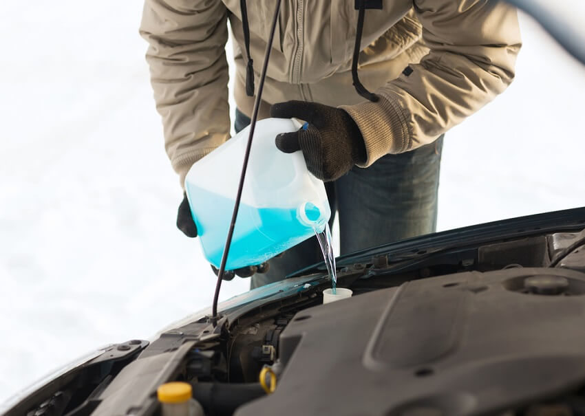 person pouring anti-freeze into their car