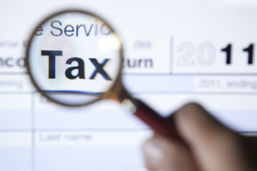 Magnifying glass highlighting the word tax