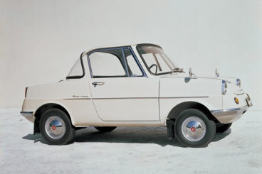 Mazda R360 in white parked in off white show room background