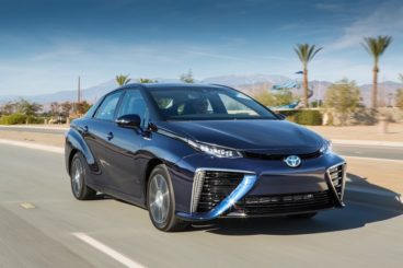 Toyota Mirai in black driving along a road with the desert behind it