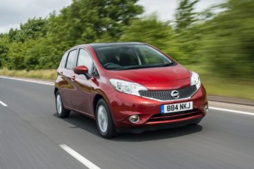 Red Nissan Note driving along a country road