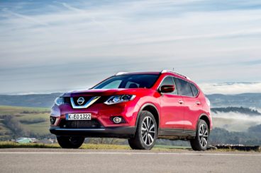 Red Nissan X-Trail in mountains