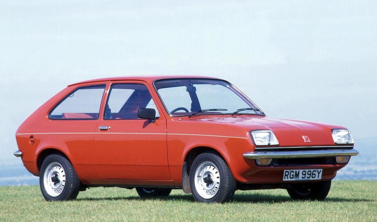 A red Vauxhall Chevette parked in the middle of a field