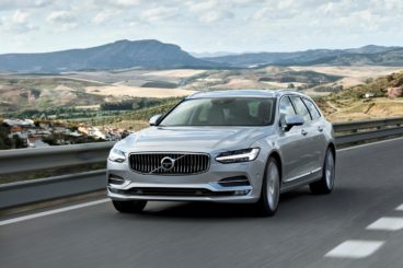 SIlver Volvo v90 driving along hilltop road