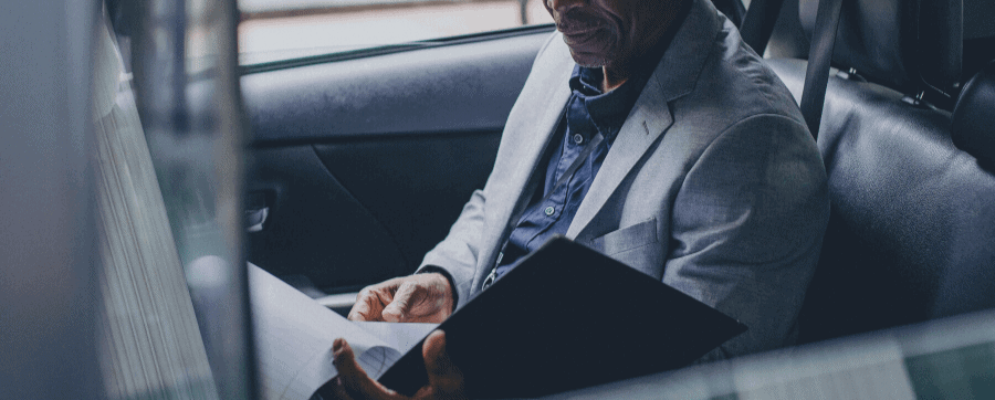 Man in a car looking at paperwork