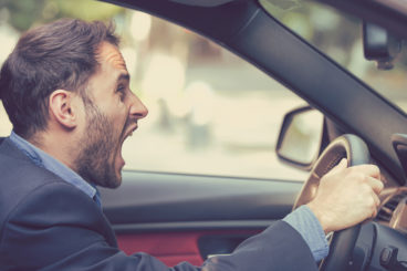 man looking very angry and shouting in a car