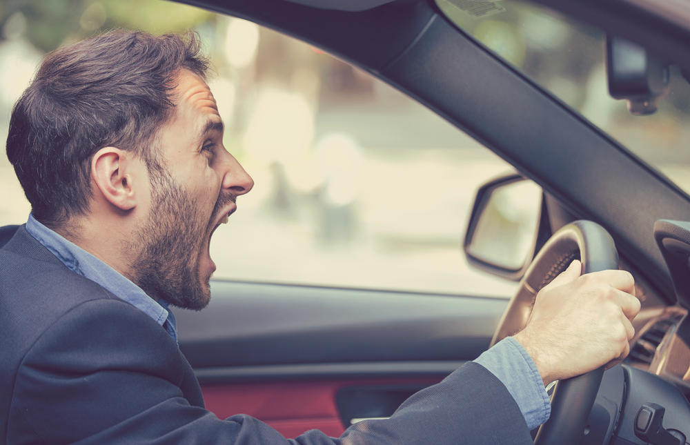 man looking very angry and shouting in a car