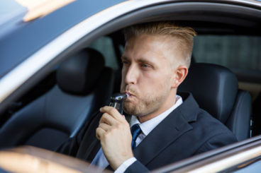 man in a suit being breathalyzed