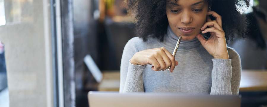 Woman on the phone while looking at her computer