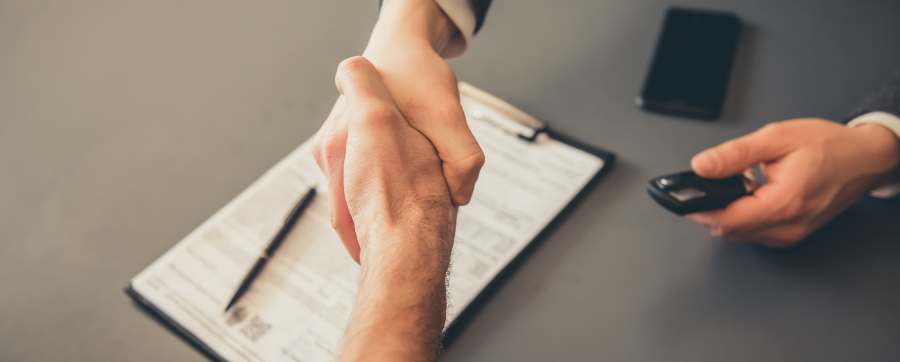 lease cars include servicing - People shaking hands over a signed contract