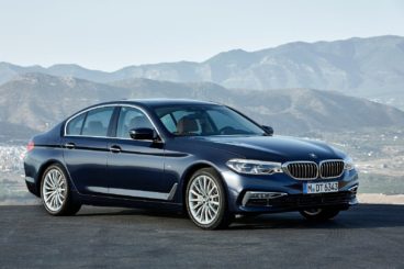 BMW 5 Series Saloon Black parked with mountains in the background