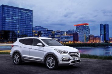 White hyundai parked with cityscape behind
