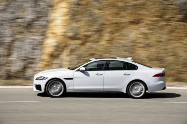 White Jaguar XF side view on the road