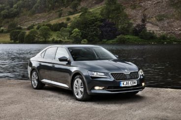 Skoda superb in black with a river behind