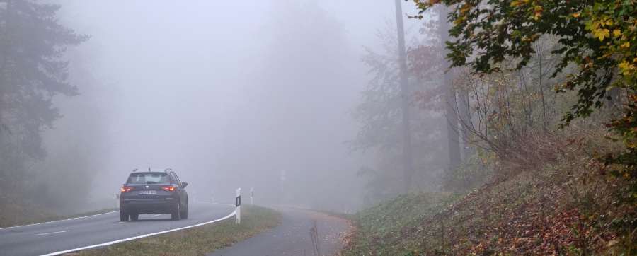 Car driving into fog