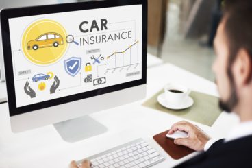 focused on computer screen that shows animations of car insurance with business man and coffee to the side