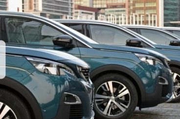 editied picture of several dark Peugeots lined up with the title fleet leasing versus buying