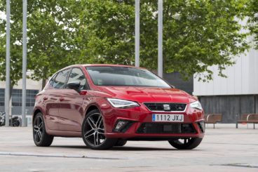 red SEAT ibiza diesel parked on street in front of green trees