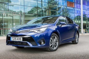 bright blue Toyota Avensis parked on tarmac in front of colourful building